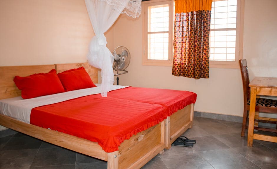 Bright and cozy bedroom interior with red bedding in Kampala, Uganda.